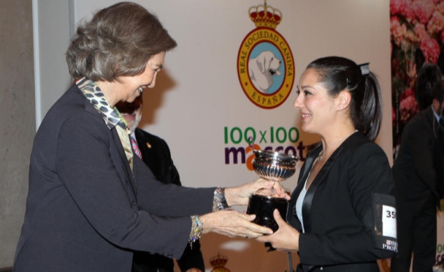 Su Majestad la Reina entrega en Trofeo de S.M. el Rey al mejor ejemplar de la Exposición a la encargada de presentar y pasear al perro ante el jurado